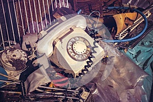 Old telephone with rotary dial and other junk yard