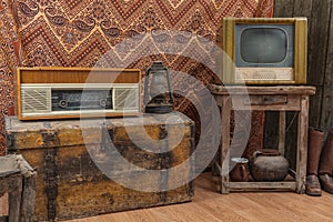 Old television, gas lantern and retro radio on wooden coffe table. Vintage color tone style