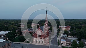 Old temple or catholic church in countryside. Wide aerial Drone view of Naperville in evening time.