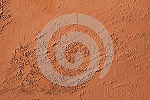 Old terracotta painted stucco wall with chipped paint. Background texture