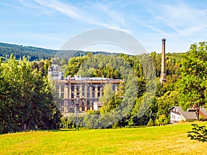 Old textile factory called Klaster, Monastery, with high chimney in summer time, Tanvald, Northern Bohemia, Czech