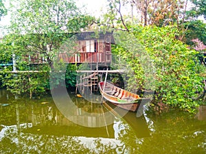 Old Thai canal side house and raw boat