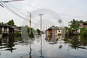 Old Thai houses on stilts, reflected from the water surface of the canals klongs of Bangkok