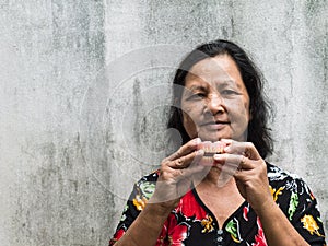 Old thai woman holding false teeth