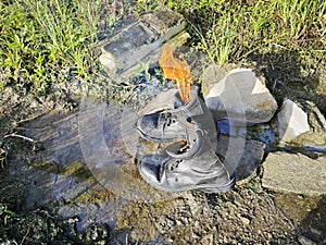 old thrown away leather boot on flame in the farm.
