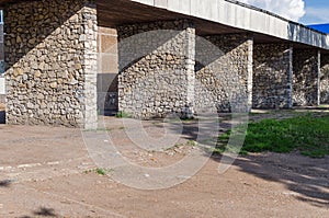 The old thrown construction with columns from a stone for the parking of buses.