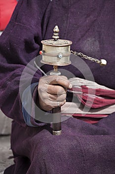 Old Tibetan man holding buddhist prayer wheel, Ladakh, India