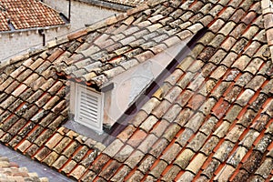 An old tiled roof of a European house with a dormer