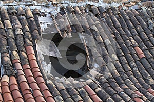 Old tiled roof with a large hole