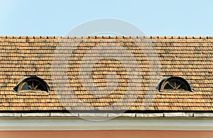 Old tiled roof with two attic windows photo