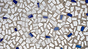 Old tiles in concrete, mosaic, broken ceramics in the building. Background of a house in the city.