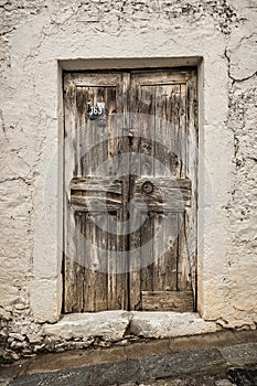 Old timber door in the scuffed wall