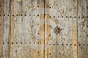 Old and time-worn solid wooden door with decorative metal elements
