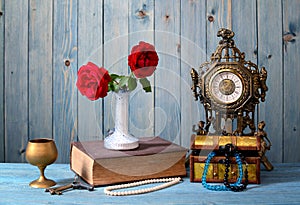Old timepiece, books, flowers and jewelry photo