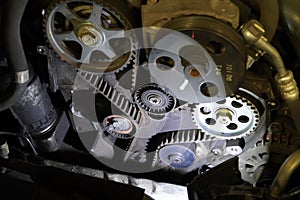 Old timing belt with rollers mounted on an old engine in the garage. concept of changing the timing belt at certain distances