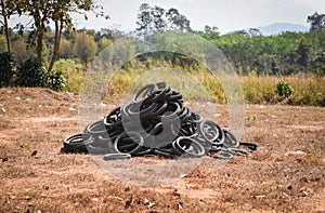 Old tires on the grass - industrial landfill for the processing of waste tires and rubber tyres pile of old tires and wheels for