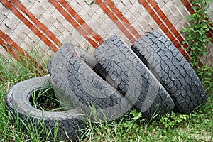 Old tires in a yard placed along a fence