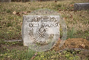 OLD TOMBSTONE WITH CROSS AND ARABIC WRITING