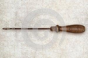 Old tool screwdriver with wooden handle isolated