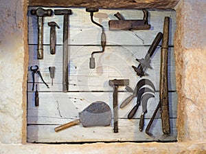 Old tools collection on wooden wall.