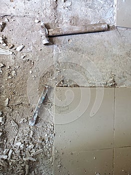 Old tools on floor. Dismantling old floor tiles. Renovations.Chisel and hammer on concrete slab. Very old construction