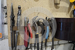 Old tools hanging on wall in workshop , Tool shelf against a wall