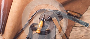 Old tools and leather at cobbler workplace. Shoemaker`s work desk. Flat lay, top view. Set of leather craft tools on wooden backg