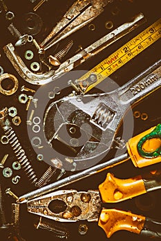 Old tools and screws on a metallic background