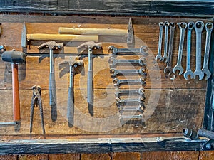 Old tools of technician hanging on wooden board