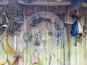 Old tools and wires on moldy village house wall