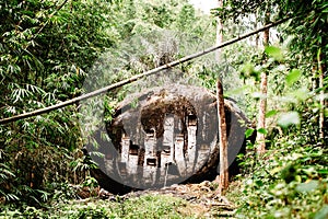 Old torajan burial site in Bori, Tana Toraja. The cemetery with coffins placed in a huge rock. Rantapao, Sulawesi, Indonesia