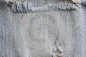 Old torn blue jeans texture close up, top view. Denim background