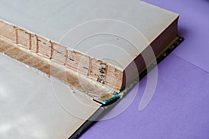 An old torn book in close-up. Open book flyleaf hardcover books. Paper book repair concept