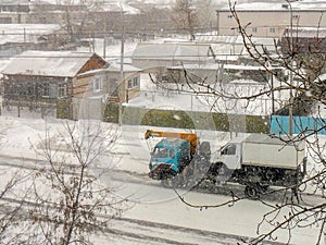 Old tow truck carries a truck in snowy weather