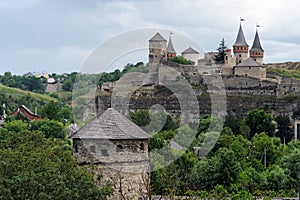 Old tower with Kamianets-Podilskyi Castle on background, Ukraine