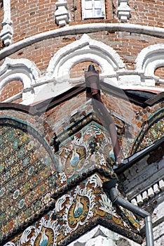 Old tower of red bricks decorated by ceramic tiles.