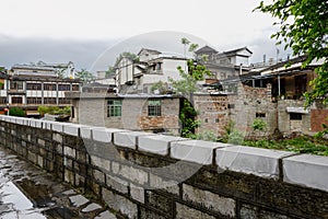 Old town behind stone wall in cloudy spring after rain