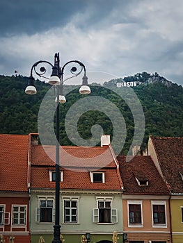 The old town of Brasov with colorful vintage buildings in traditional saxon style with the view to the sign on top of the hill.
