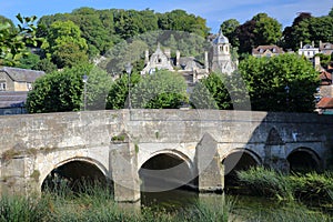 The Old Town Bridge on the river Avon with the bell tower of St Thomas More`s Catholic Church in the background, Bradford on Avon,