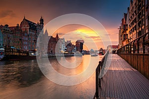 Old town in Gdansk with historical port crane over Motlawa river at rainy sunset, Poland