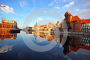 Old town of Gdansk reflected in Motlawa river at sunrise.