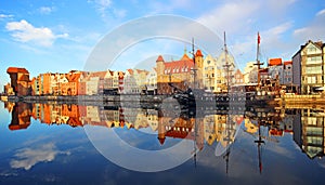 Old town of Gdansk reflected in Motlawa river at sunrise.