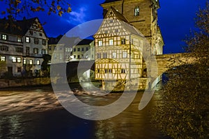 Old town hall or Altes Rathaus with two bridges over the Regnitz river at night in Bamberg, Bavaria, Franconia, Germany