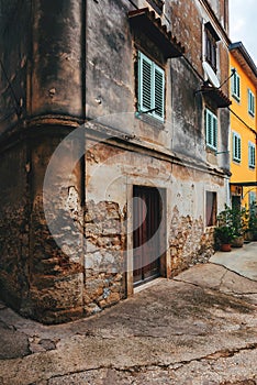 Old town of Lovran in Croatia, distinctive Istrian architecture with worn facades and wooden window shutters