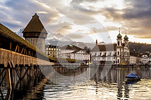 Old town of Lucerne, Switzerland at sunset in winter. Famous wooden Chapel Bridge on Reuss river, Jesuit Church