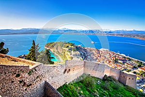 Old town of Nafplion in Greece view from above with tiled roofs, small port and bourtzi castle on the Mediterranean sea.