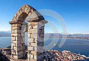 Old town of Nafplion in Greece view from bell tower, with tiled roofs, small port and bourtzi castle on the Mediterranean sea.