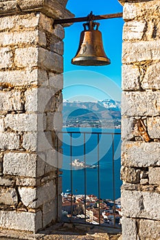 Old town of Nafplion in Greece view from bell tower, with tiled roofs, small port and bourtzi castle on the Mediterranean sea.