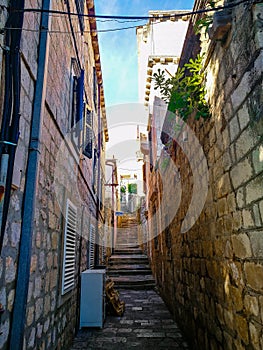Old town narrow street with stairs, doors, windows and flower garlands Croatia