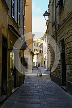 Old town with narrow streets and roads of Lavagna, Liguria, Italy. A kid riding a bike